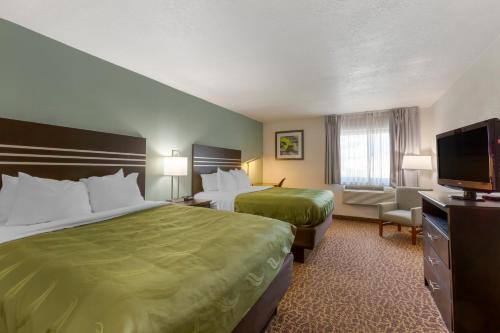 a hotel room with two beds and a flat screen tv at Quality Inn Alexis Rd in Toledo