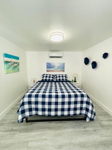 een slaapkamer met een bed met een zwart-wit geruite deken bij Our Lovely Nest, Free Parking & Wi-Fi in Miami