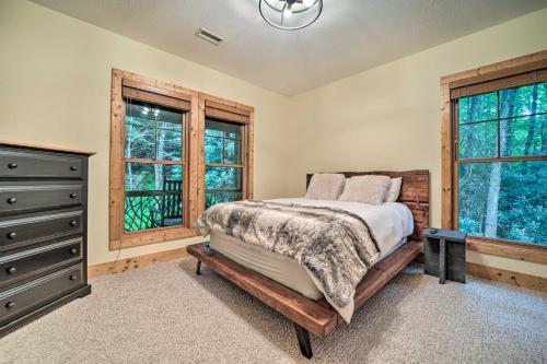 a bedroom with a bed and a dresser and windows at Secluded Sapphire Chalet with Game Room and Decks in Sapphire