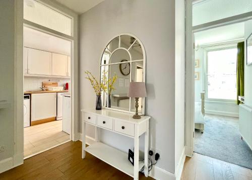 a room with a white dresser and a mirror at South Bridge Apartment in Edinburgh