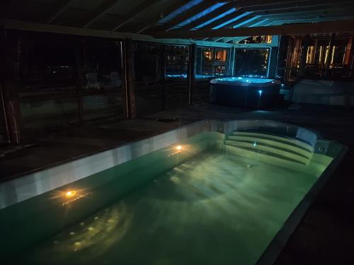 a swimming pool at night with lights in it at Leśna Osada Szegdy 