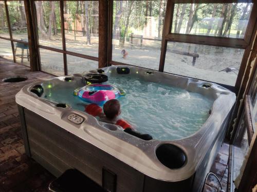 a child in a jacuzzi tub in a house at Leśna Osada Szegdy in Szegdy