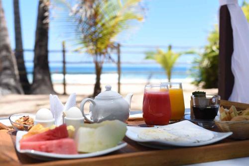 uma mesa com comida e bebidas na praia em Rumah Pousada em Barra Grande