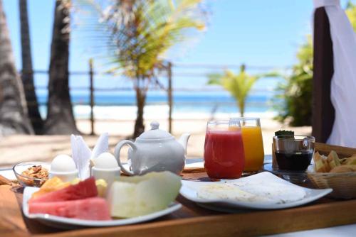 a table with food and drinks on the beach at Rumah Pousada in Barra Grande