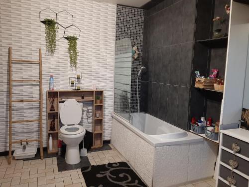 une salle de bain avec toilettes, baignoire et lavabo dans l'établissement LA GRAN'EXOTIQUE, à Nouvion-en-Ponthieu
