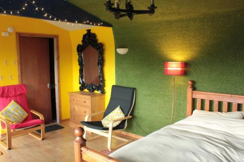 um quarto com uma cama, uma cadeira e um espelho em Couples Camping Cabin em Ashbourne