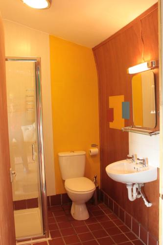 a bathroom with a toilet and a sink at Couples Camping Cabin in Ashbourne
