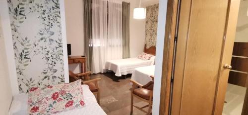 a hotel room with a bedroom with a bed and a room at Hotel Corona de Atarfe in Atarfe