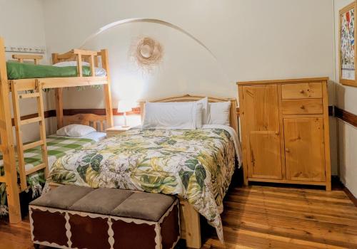 a bedroom with a bed and a ladder and bunk beds at La Casa Cuencana in Cuenca
