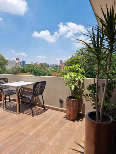 a patio with a table and chairs on a balcony at Condesa Cibel in Mexico City