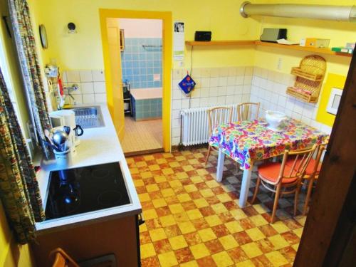 eine Küche mit einem Tisch und Stühlen sowie eine Küche mit einem Bad in der Unterkunft Ferienhaus Haus am Ufer in Gaienhofen