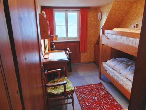 Kleines Zimmer mit einem Schreibtisch und Etagenbetten. in der Unterkunft Ferienhaus Haus am Ufer in Gaienhofen