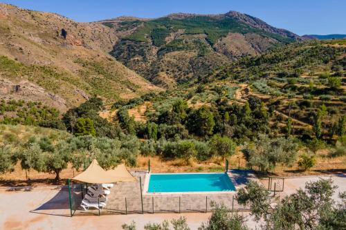 - une vue sur la piscine et les montagnes en arrière-plan dans l'établissement Cortijo El Chopo Almería, à Bayarque