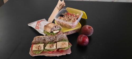a sandwich and a container of coleslaw and a salad at Les Vagabonds du Mont in Chichilianne