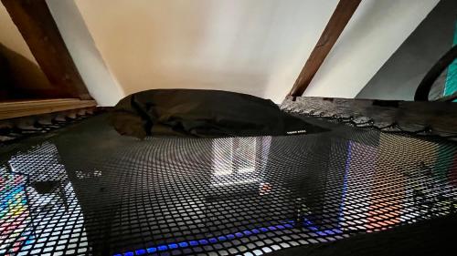 a black bag sitting on the floor in a room at Capsule Art Déco - Jacuzzi - Netflix - Home Cinéma - Arcade de jeux & Nintendo switch - 2 chambres - Filet suspendu in Valenciennes