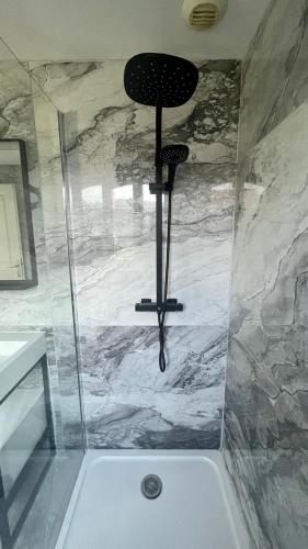 a shower with a black chair in a bathroom at Capsule Art Déco - Jacuzzi - Netflix - Home Cinéma - Arcade de jeux & Nintendo switch - 2 chambres - Filet suspendu in Valenciennes