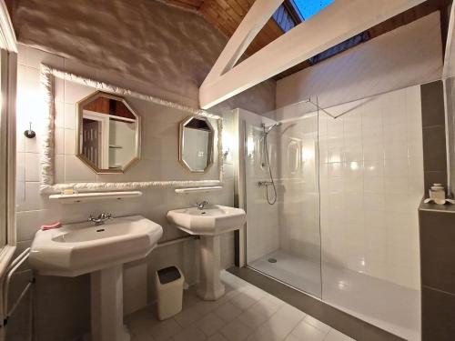 a bathroom with two sinks and a shower at Gîtes Elusate in Eauze