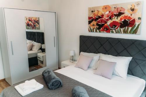 a bedroom with a bed and a large mirror at Apartman Star #1 in Vinkovci