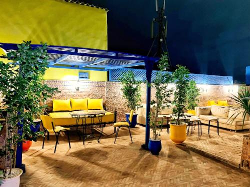a patio with yellow tables and chairs and plants at Riad Majorelle in Rabat