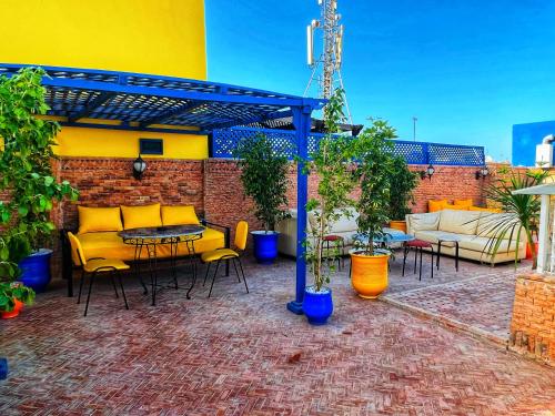 a patio with a table and chairs and a brick wall at Riad Majorelle in Rabat