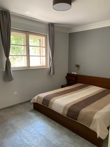 a bedroom with a bed and two windows at Stefánia Apartmanok Budapest in Budapest