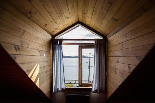 a window in a room with a view of the ocean at Hostal Mundo Nuevo in Ancud