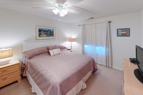 1 dormitorio con 1 cama con ventilador de techo y TV en Seaside - Sand Dollar C-103, en Virginia Beach
