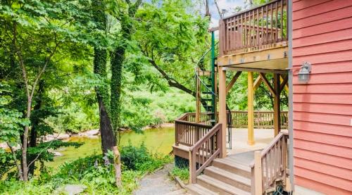 a deck on the side of a red house at River's Edge in Cullowhee