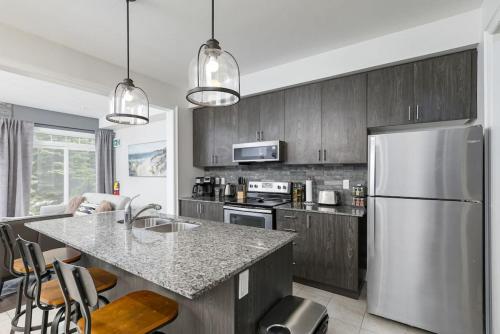a kitchen with a stainless steel refrigerator and a counter at Exceptional 3 BDRM Townhome - 4 Seasons Rental in Collingwood