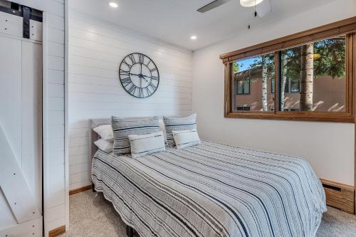 1 dormitorio con 1 cama y reloj en la pared en Laurelwood Condominiums 102 en Snowmass Village