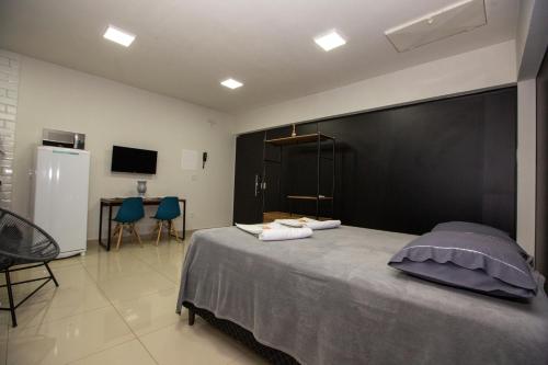 a bedroom with a large bed and a table and chairs at Jahu Center Plaza Flats in Jaú