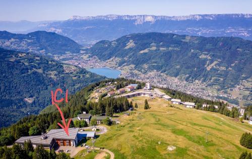 uma vista aérea de uma casa numa colina com montanhas em Family apartment on the skiing slope em Allevard