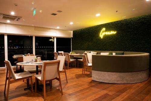 a restaurant with tables and chairs and a green wall at Novotel Sao Paulo Morumbi in Sao Paulo