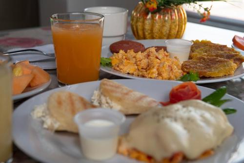 uma mesa coberta com pratos de alimentos e bebidas em Hotel La Casa 1 em Montería