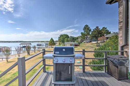 a grill on a deck with a view of the water at Modern Cedar Creek Lake Retreat with Panoramic View! in Malakoff