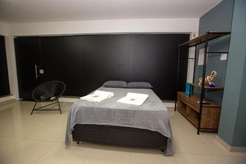 a bedroom with a bed and a black wall at Jahu Center Plaza Flats in Jaú