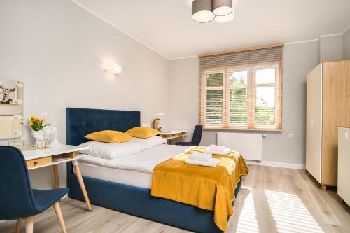 a small bedroom with a bed and a desk and a desk at Apartament na Wspólnej in Elblag