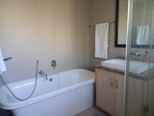 ein Badezimmer mit einer Badewanne und einem Waschbecken in der Unterkunft Mount Royal 31 - Large 1 bed with balcony in Johannesburg