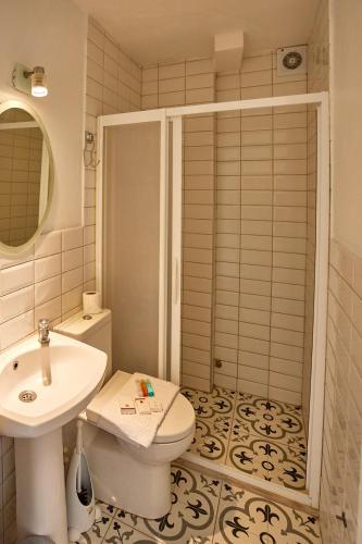a bathroom with a sink and a toilet and a shower at Degirmenli Konak Hotel in Alaçatı