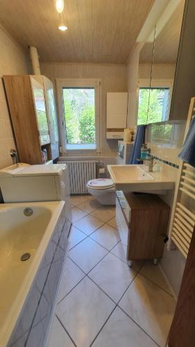 a large bathroom with two sinks and a toilet at Ferienhaus Am Vitzerod in Tambach-Dietharz