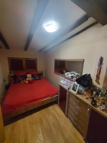 a small bedroom with a red bed and a desk at Samra in Sarajevo