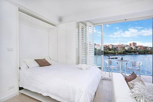um quarto com uma cama e vista para a água em BADEN - Absolute Water Front Sydney Harbour Studio em Sidney