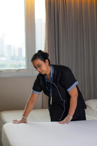 a woman leaning on a bed in a room at Novotel Sao Paulo Morumbi in Sao Paulo