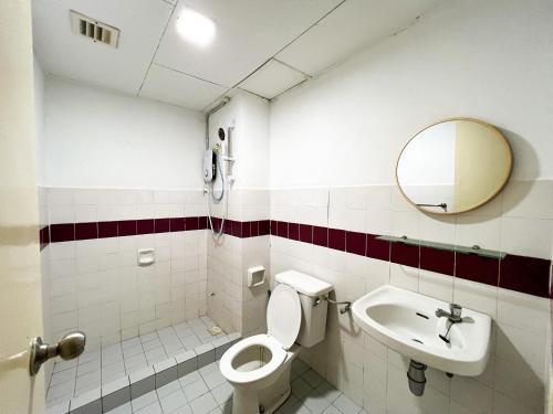 a bathroom with a toilet and a sink and a mirror at BayView Suites Port Dickson By MAISON in Port Dickson