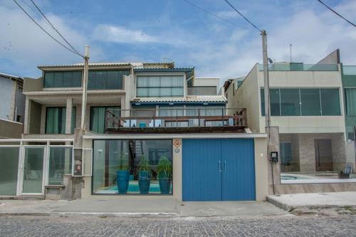 um edifício com uma porta azul e janelas em Casa do Beiral Azul 5 Qts Pé na areia Piscina em Cabo Frio