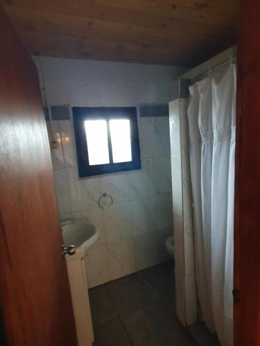 a bathroom with a shower and a sink and a window at Ave Fénix in Aguas Dulces