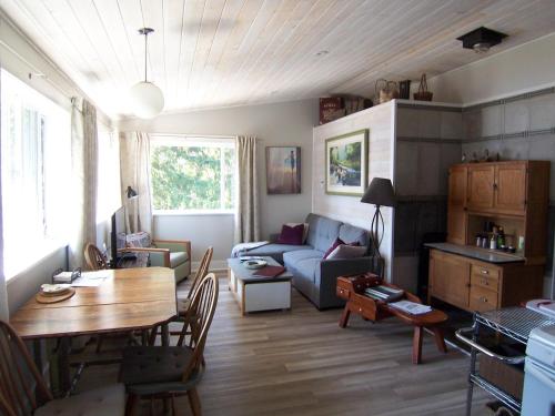 een woonkamer met een bank en een tafel bij Malaspina Strait Cottage in Powell River