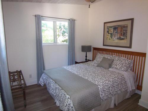 Schlafzimmer mit einem Bett und einem Fenster in der Unterkunft Malaspina Strait Cottage in Powell River