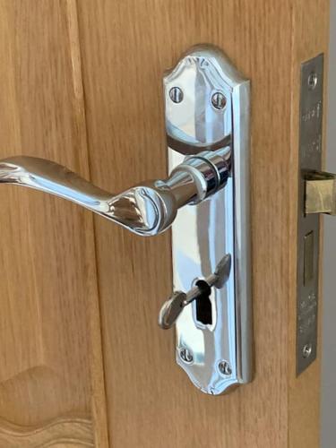 a metal door handle on a wooden door at Lovekush Epsom Banstead Surrey. Views over London in Ewell