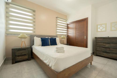 ein Schlafzimmer mit einem großen Bett mit blauen Kissen in der Unterkunft Soha suites I in Santiago de los Caballeros
